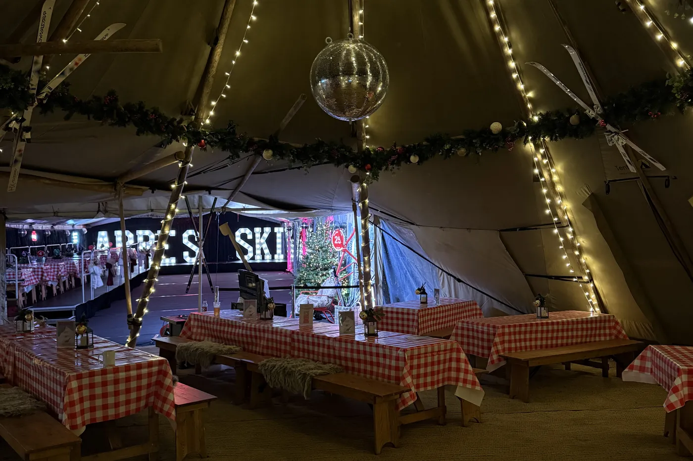 The tipi dressed with fairy lights, garlands and gingham tables