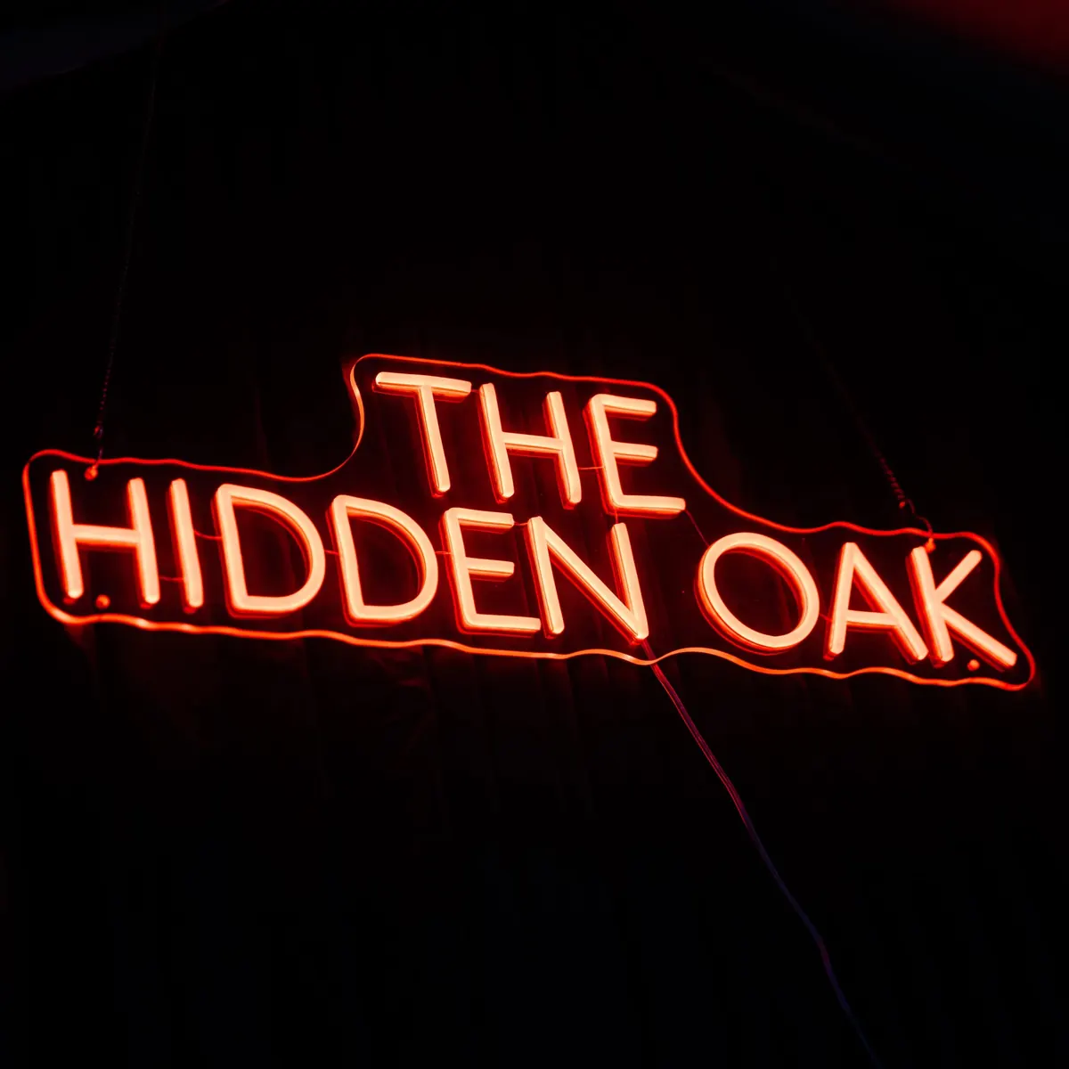The Hidden Oak neon sign glowing