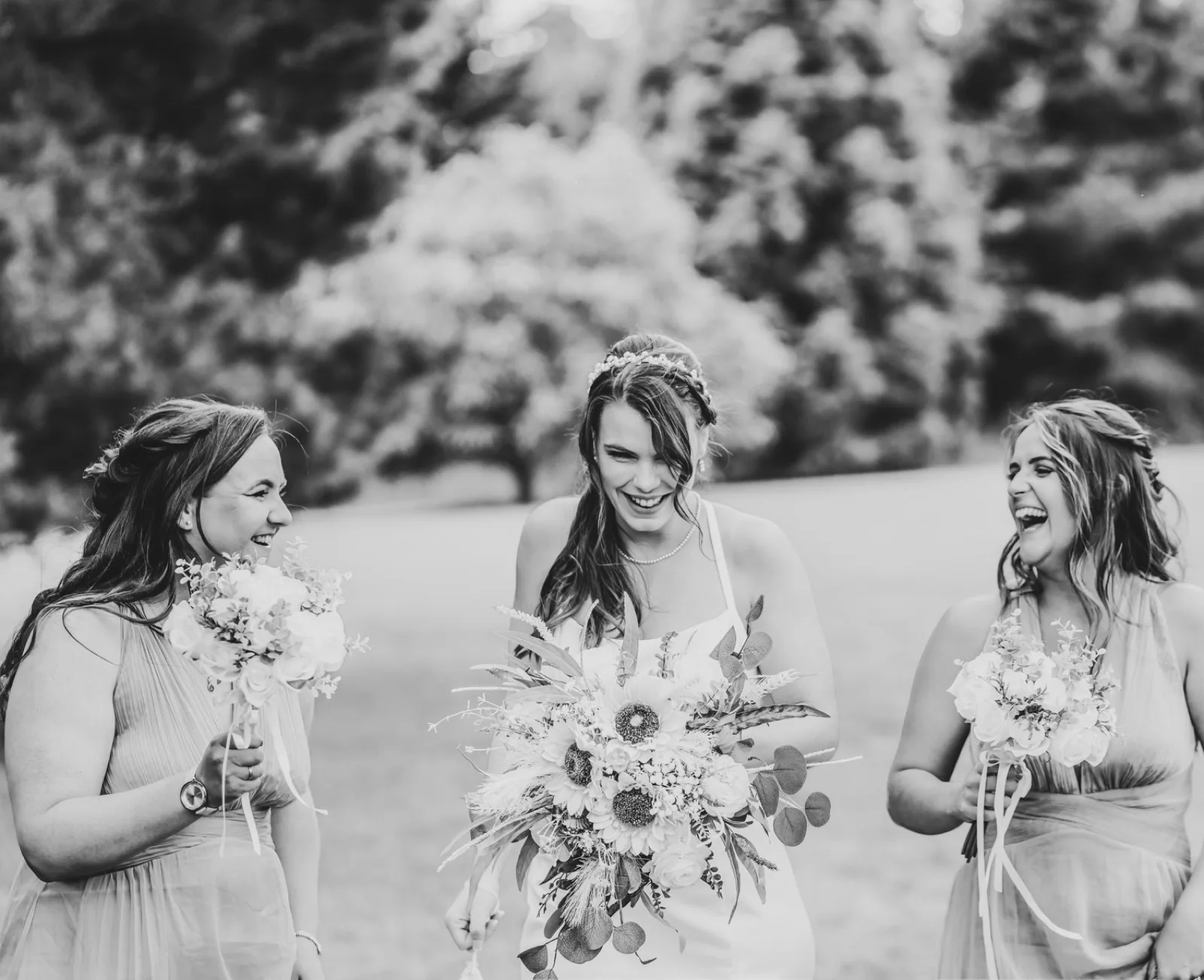Bridesmaids laughing with their bouquets