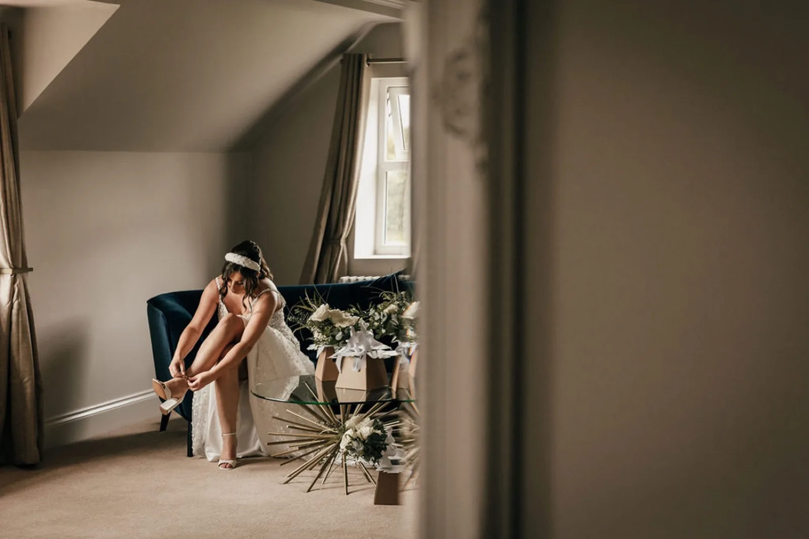 A bride fastening her shoes while getting ready