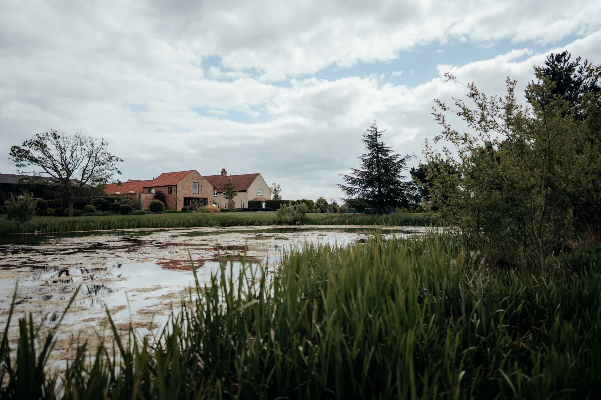The Farmhouse at The Hidden Oak across the lake in spring.