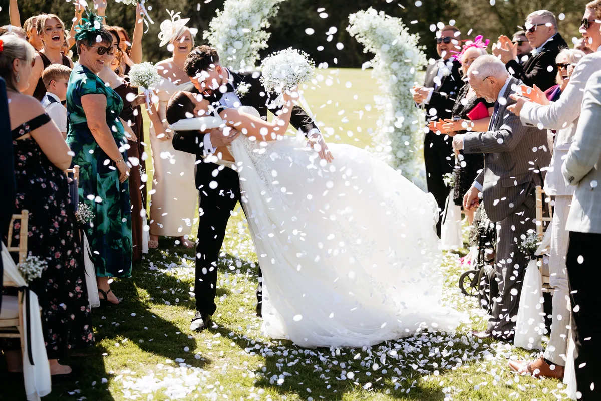 A kiss in the confetti at the top of the aisle